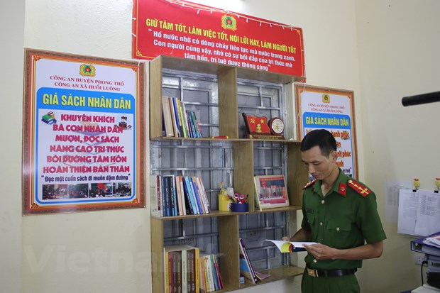 Đại tá Đoàn Tá Chinh, Công an xã Huổi Luông bên“Giá sách nhân dân." (Ảnh: Hùng Võ/Vietnam+)